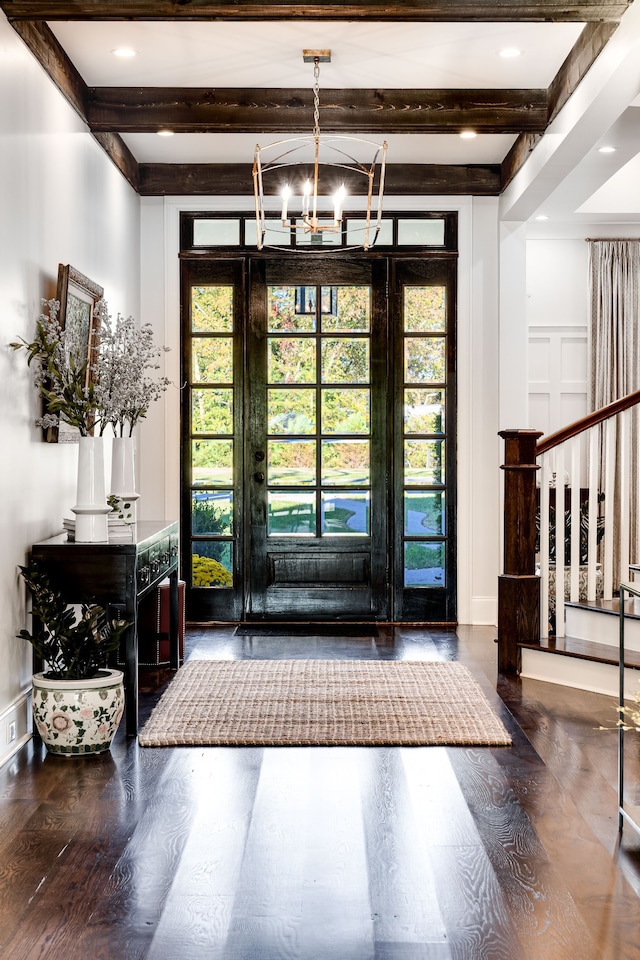 entrance foyer featuring an inviting chandelier, hardwood / wood-style floors, and beamed ceiling