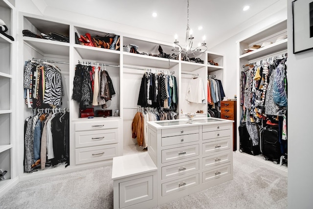 walk in closet featuring light carpet and a chandelier