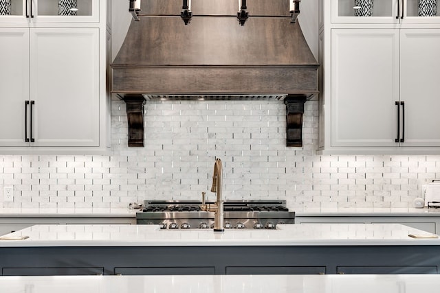 kitchen featuring backsplash, sink, and white cabinets