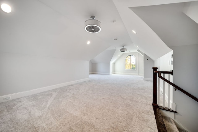 bonus room with vaulted ceiling and light colored carpet