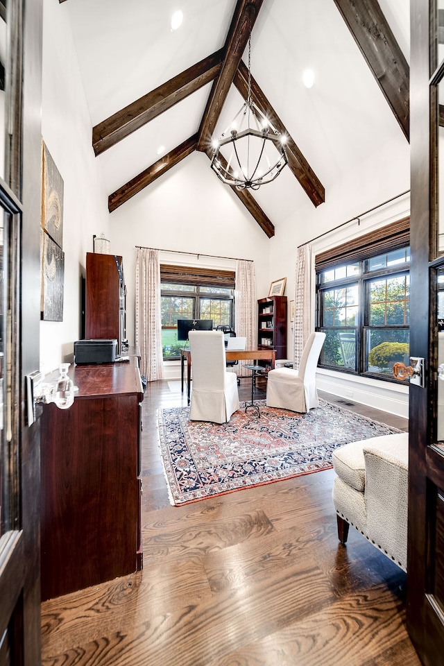 living room with dark wood-type flooring, beamed ceiling, a wealth of natural light, and an inviting chandelier