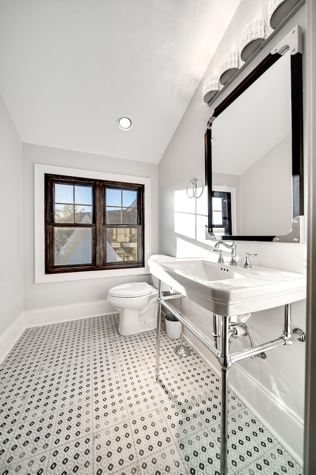 bathroom with toilet and lofted ceiling