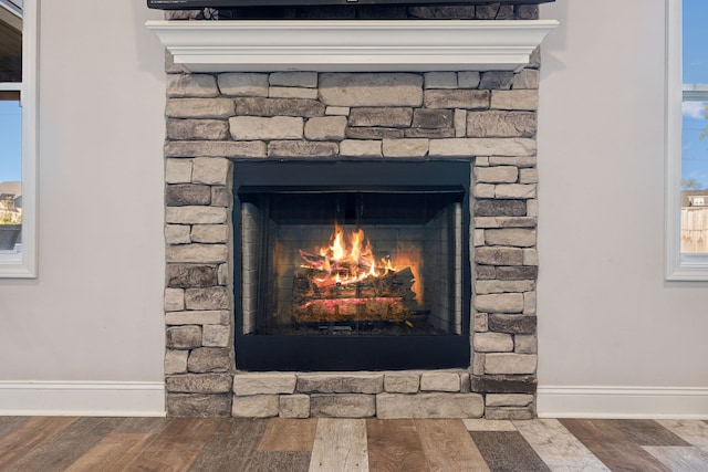 interior details with a stone fireplace and hardwood / wood-style flooring