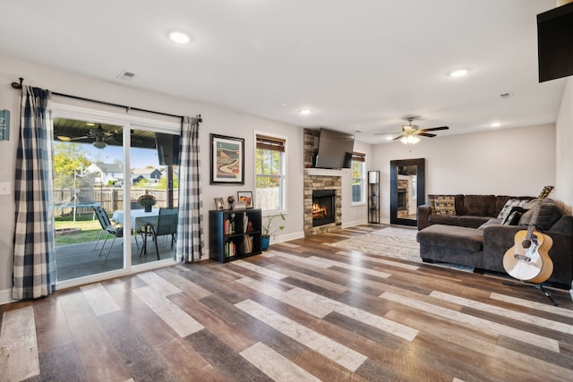 unfurnished living room featuring ceiling fan, hardwood / wood-style flooring, and a fireplace