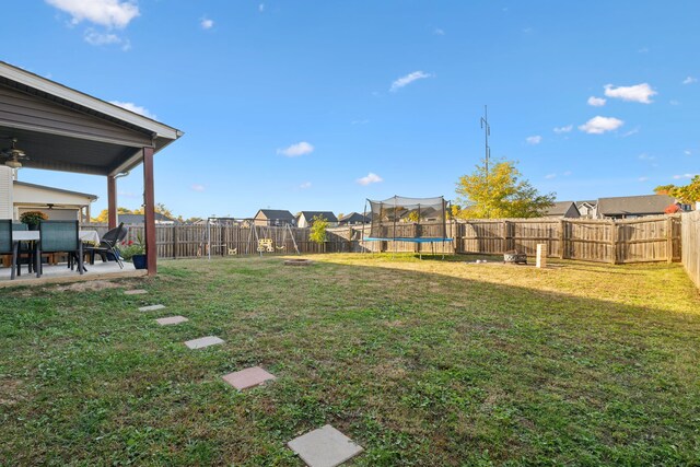 view of yard featuring a trampoline and a patio