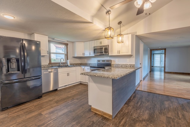 kitchen featuring kitchen peninsula, appliances with stainless steel finishes, light stone countertops, and white cabinets