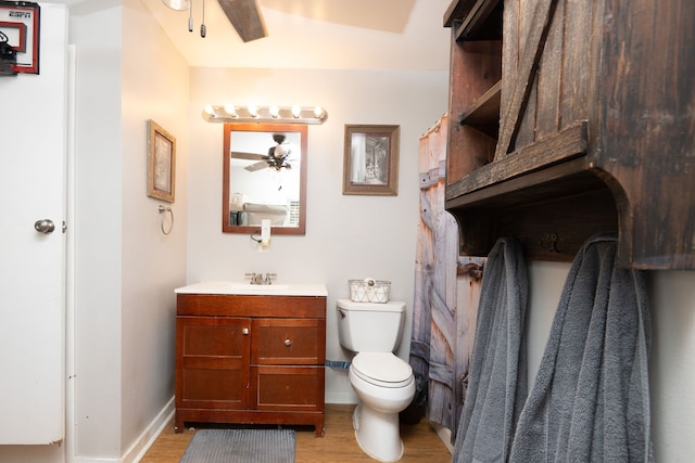 bathroom featuring vanity, hardwood / wood-style flooring, toilet, and ceiling fan