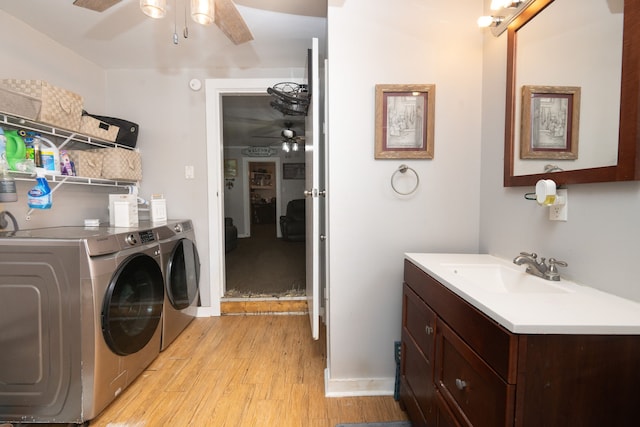 washroom with ceiling fan, sink, light wood-type flooring, and washing machine and clothes dryer