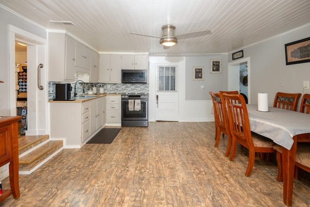 kitchen with ceiling fan, appliances with stainless steel finishes, ornamental molding, dark wood-type flooring, and sink