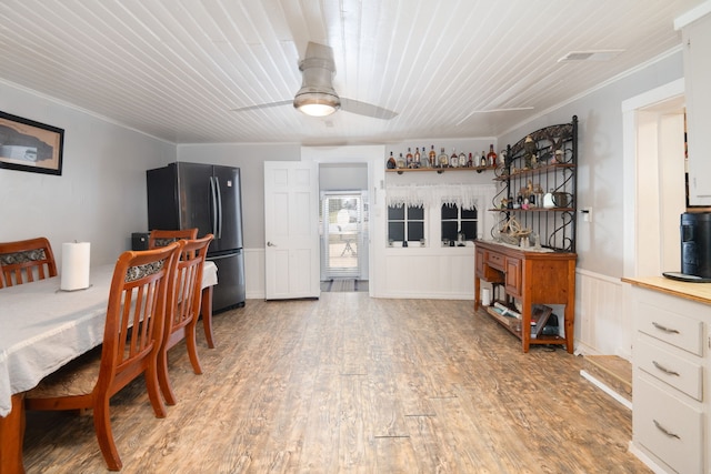 dining space with ceiling fan, crown molding, and light hardwood / wood-style floors