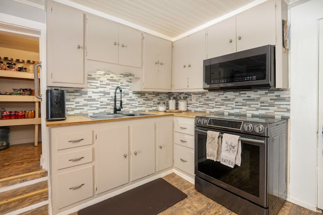 kitchen with decorative backsplash, stainless steel appliances, sink, light wood-type flooring, and white cabinetry