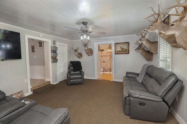 carpeted living room featuring ornamental molding and ceiling fan