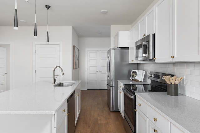 kitchen featuring light stone counters, white cabinetry, stainless steel appliances, dark wood-type flooring, and decorative light fixtures