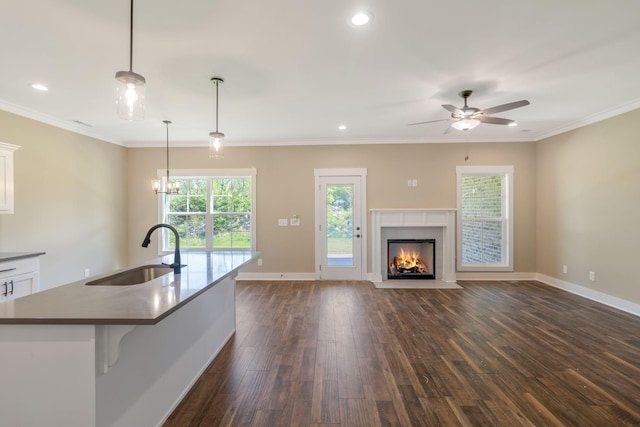 kitchen with white cabinetry, a sink, dark wood-style flooring, baseboards, and ceiling fan