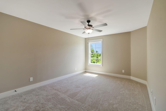 spare room with carpet flooring, baseboards, and ceiling fan