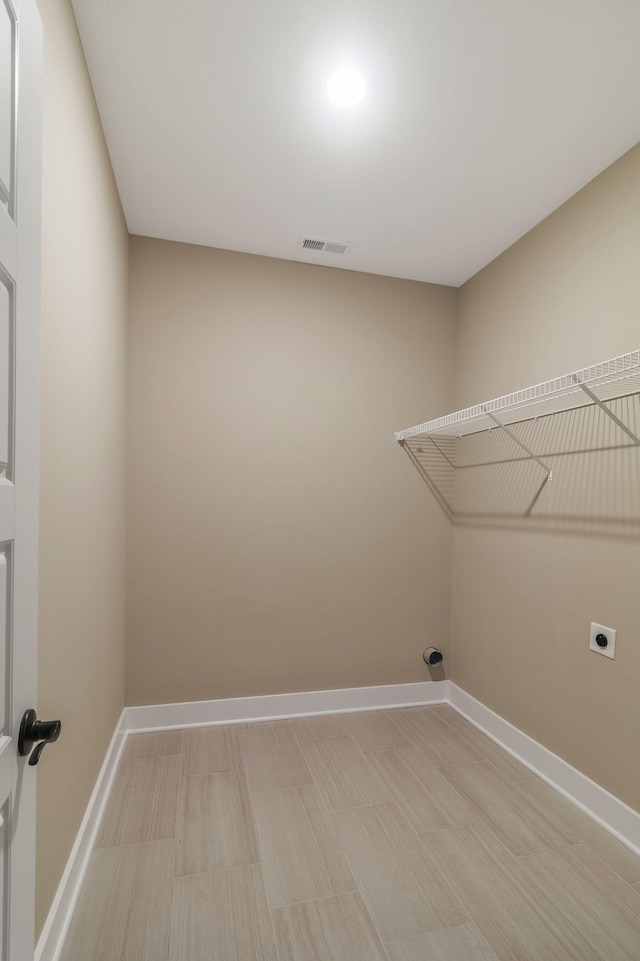 laundry area featuring baseboards, visible vents, laundry area, and hookup for an electric dryer