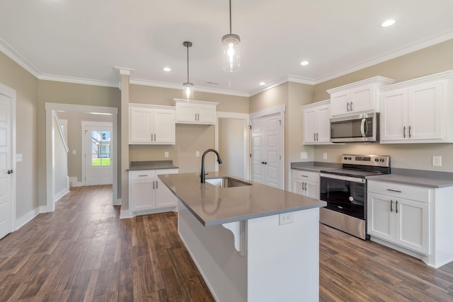 kitchen featuring a sink, stainless steel appliances, a center island with sink, dark wood finished floors, and white cabinetry