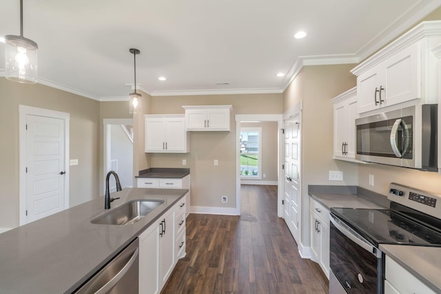 kitchen with dark countertops, a sink, white cabinets, appliances with stainless steel finishes, and dark wood-type flooring