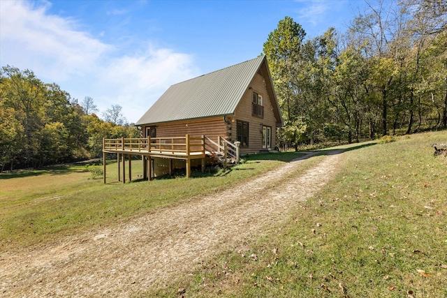 view of side of home with a yard and a deck