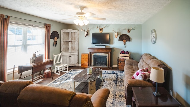 living room with ceiling fan, wood-type flooring, and a textured ceiling