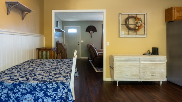 bedroom with a textured ceiling and dark hardwood / wood-style floors