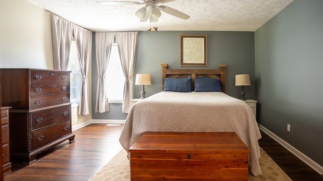 bedroom with dark hardwood / wood-style flooring, a textured ceiling, and ceiling fan