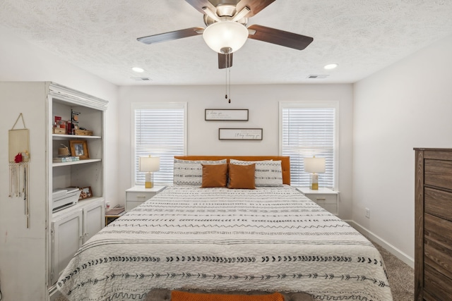 bedroom with ceiling fan, a textured ceiling, and carpet floors