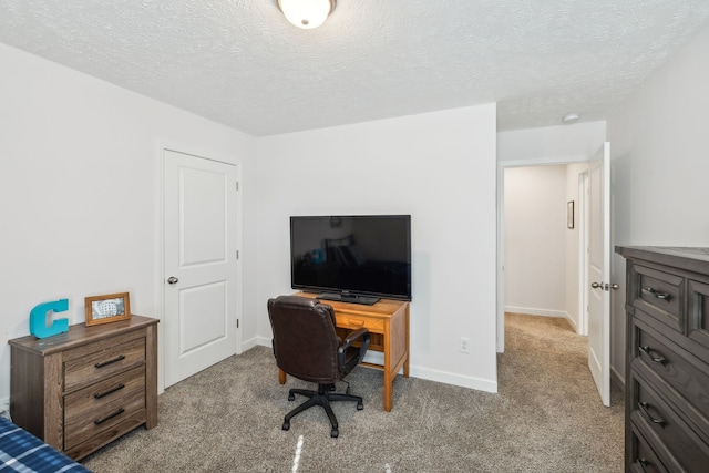 home office featuring a textured ceiling and light colored carpet