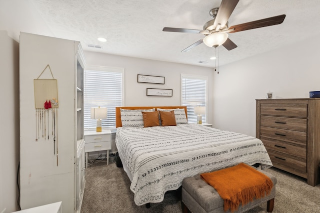 carpeted bedroom featuring a textured ceiling and ceiling fan