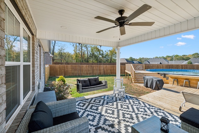 view of patio featuring area for grilling, ceiling fan, a pool side deck, and outdoor lounge area