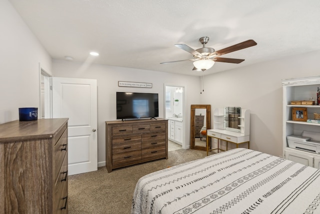 bedroom featuring ensuite bathroom, light colored carpet, and ceiling fan