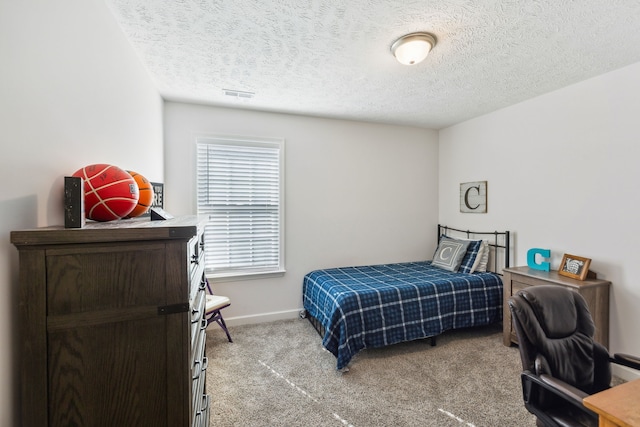 bedroom featuring a textured ceiling and light colored carpet