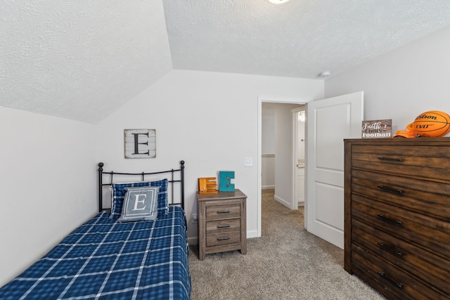 bedroom featuring lofted ceiling, a textured ceiling, and light colored carpet