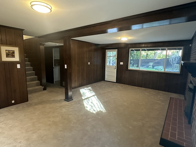 carpeted foyer featuring wood walls