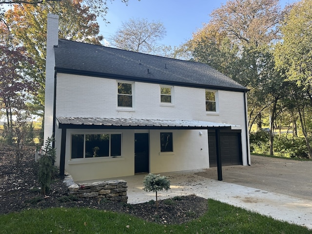 rear view of property with a garage