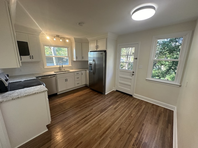 kitchen featuring a wealth of natural light, appliances with stainless steel finishes, white cabinetry, and dark hardwood / wood-style flooring