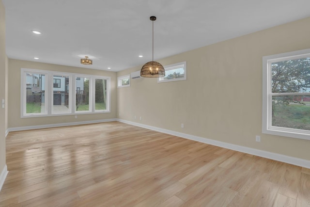 interior space with a wall unit AC and light wood-type flooring