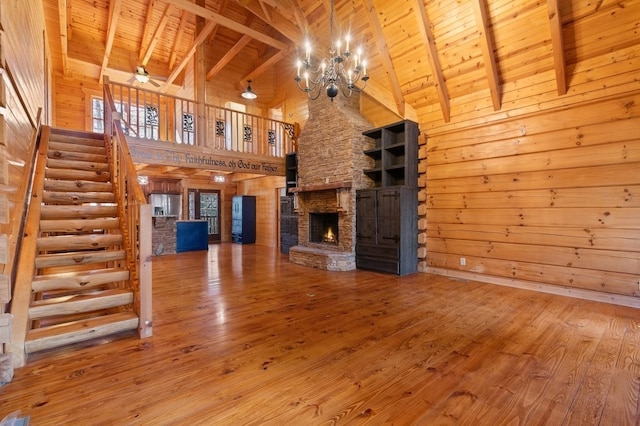 unfurnished living room with a fireplace, wood ceiling, wooden walls, and hardwood / wood-style floors