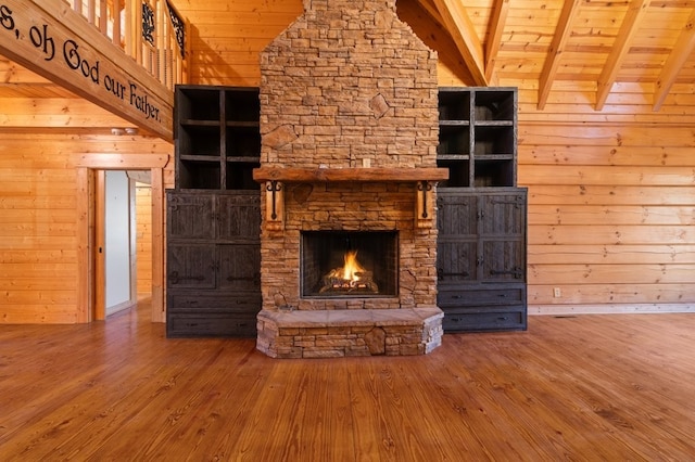 unfurnished living room with wood-type flooring, wooden walls, and beam ceiling