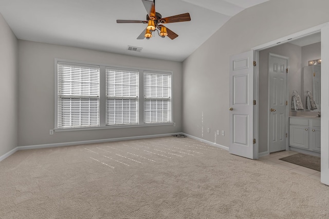 carpeted spare room with ceiling fan and vaulted ceiling