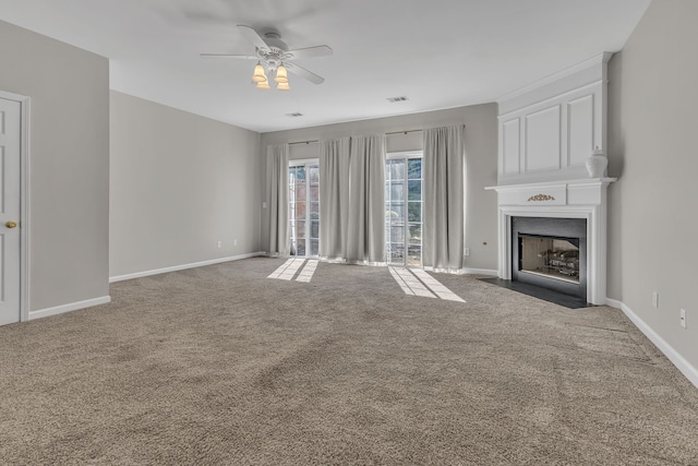 unfurnished living room featuring ceiling fan, a large fireplace, and dark carpet