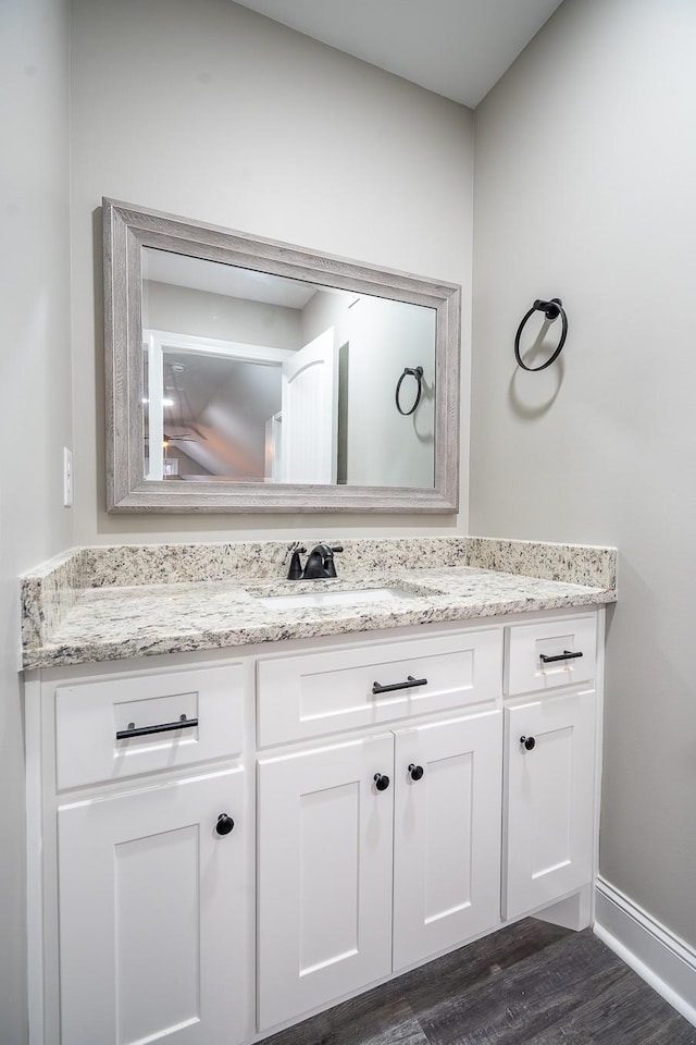 bathroom featuring vanity, wood finished floors, and baseboards