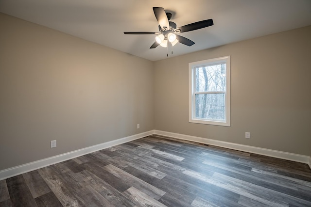 spare room with a ceiling fan, baseboards, and dark wood-style flooring