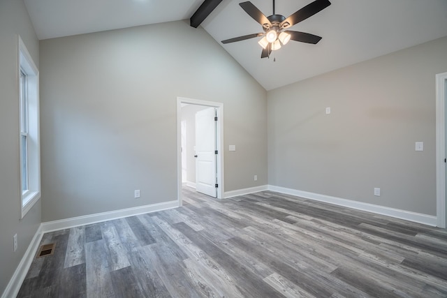 unfurnished room featuring visible vents, baseboards, beam ceiling, wood finished floors, and high vaulted ceiling