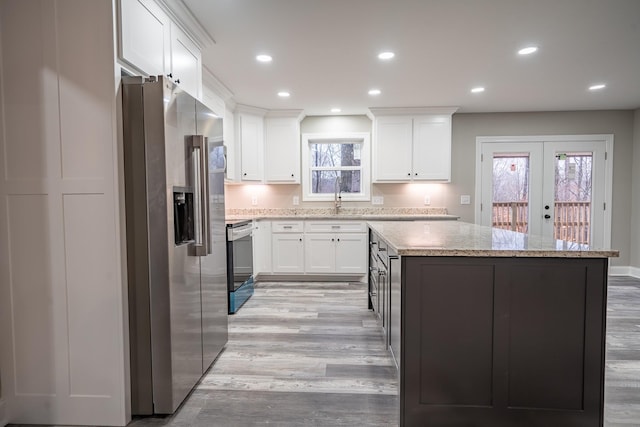 kitchen with electric range, light wood-style flooring, a center island, recessed lighting, and stainless steel fridge