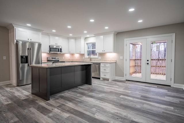 kitchen with french doors, recessed lighting, appliances with stainless steel finishes, and a center island