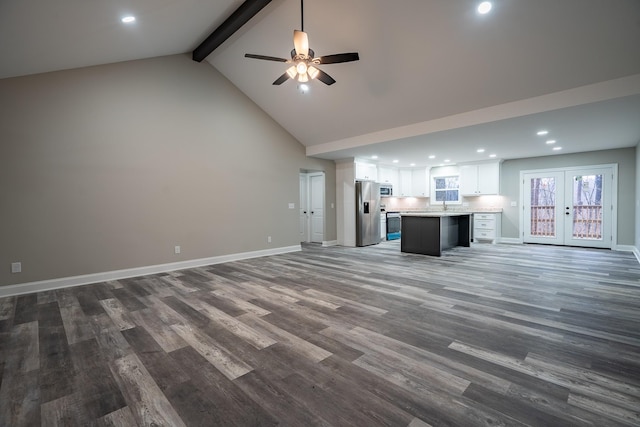 unfurnished living room featuring baseboards, high vaulted ceiling, a sink, dark wood-type flooring, and beamed ceiling