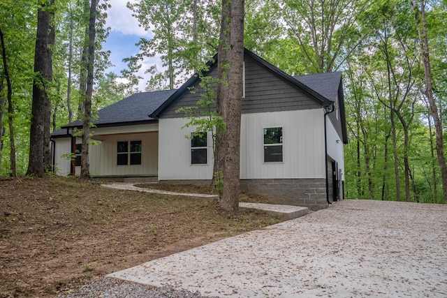 exterior space featuring driveway and a shingled roof