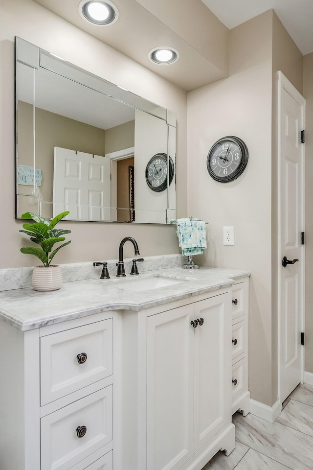 bathroom with marble finish floor and vanity