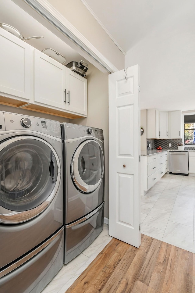 washroom featuring cabinet space, independent washer and dryer, marble finish floor, and crown molding